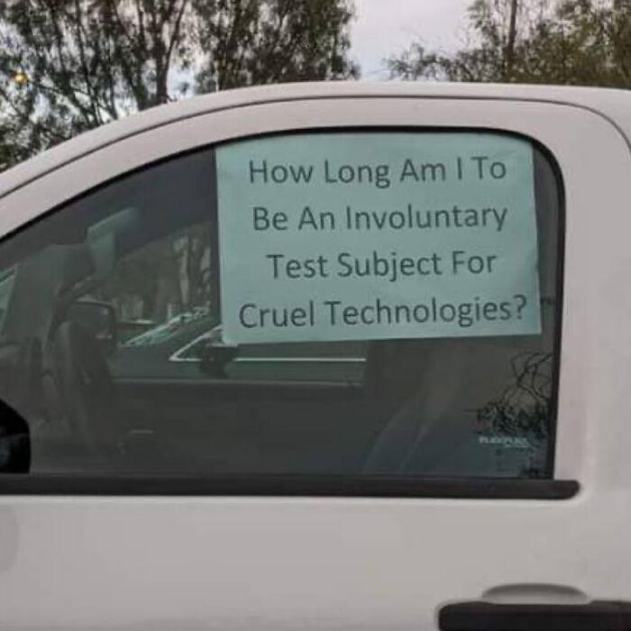 A sign on a car window asks, How Long Am I To Be An Involuntary Test Subject For Cruel Technologies? Hilarious meme.