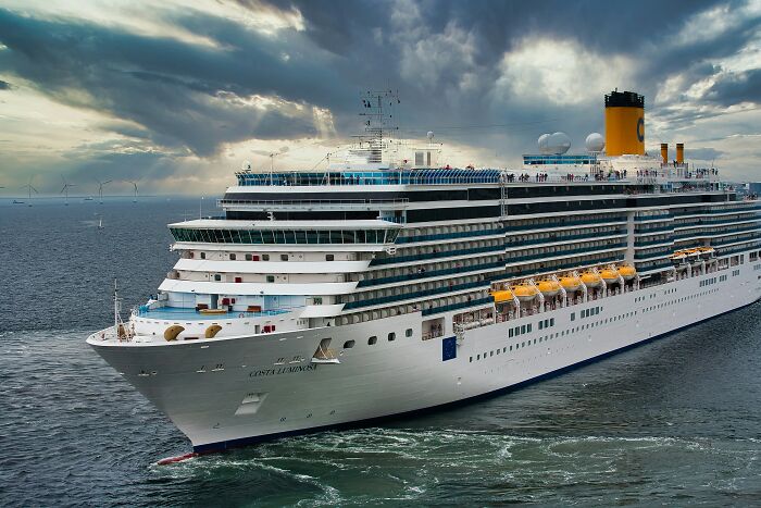 A large cruise ship, Costa Luminosa, sailing on the ocean under a dramatic sky, representing the random things people did that got them rich.