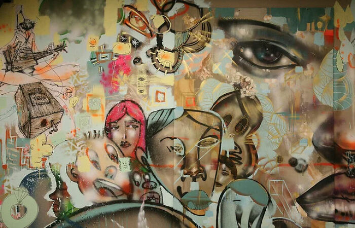 A vibrant, eclectic mural with abstract faces and designs, depicting the diverse and random paths to wealth.