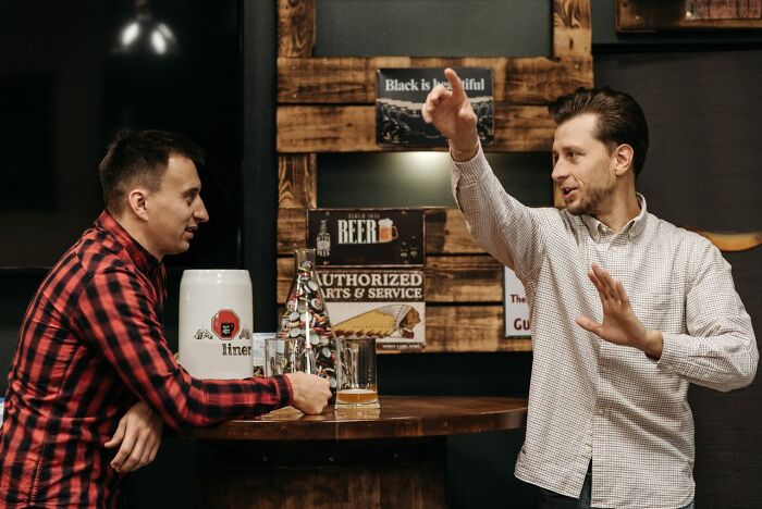Two men talking at a bar, possibly discussing friendships that fell apart after years of being close.