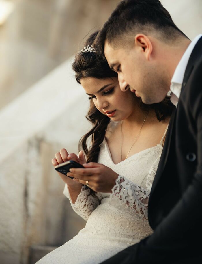 A couple looking at a smartphone together, symbolizing how friendships fall apart and relationships are tested.
