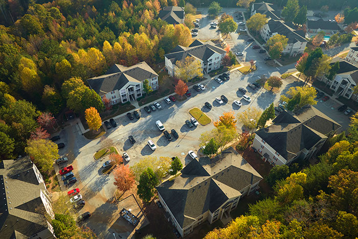 Aerial view of homes and land, with colorful autumn trees, depicting a man who owns his home free of HOA rules. Aerial view of homes and land, with colorful autumn trees, depicting a man who owns his home free of HOA rules.