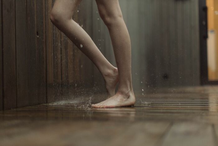 Bare feet splashing water on a wooden floor, representing a moment of luxury or an experience that left people speechless.