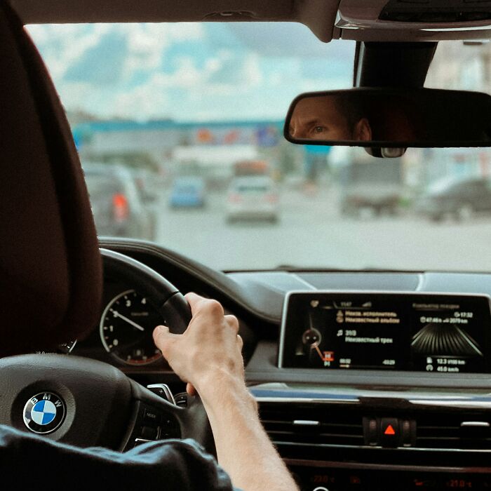 A person driving a luxury car, reflecting the wild moments experienced by people who worked for the rich.