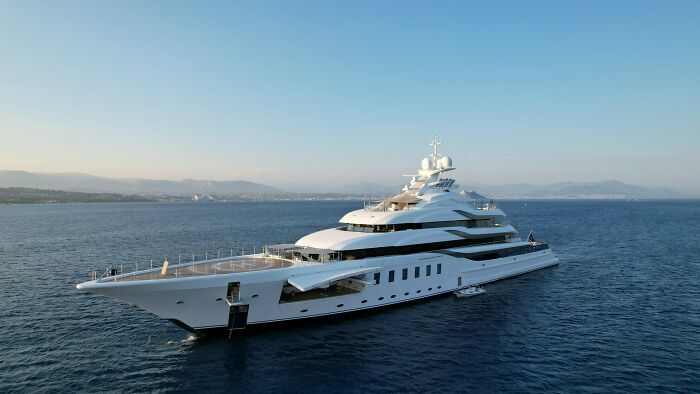 A large white luxury yacht on the water, symbolizing the wild moments and experiences of the rich.