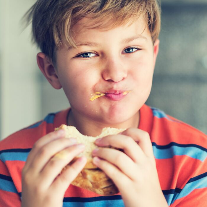 A young boy with messy blonde hair eats a sandwich. Moments that left people speechless.