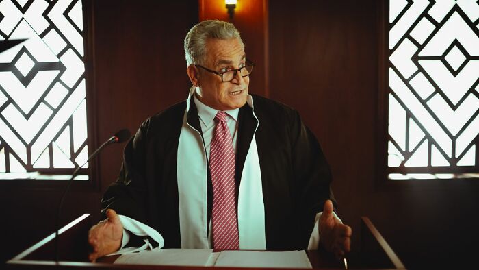 Judge or lawyer speaking at a podium in a courtroom, central to court case stories.
