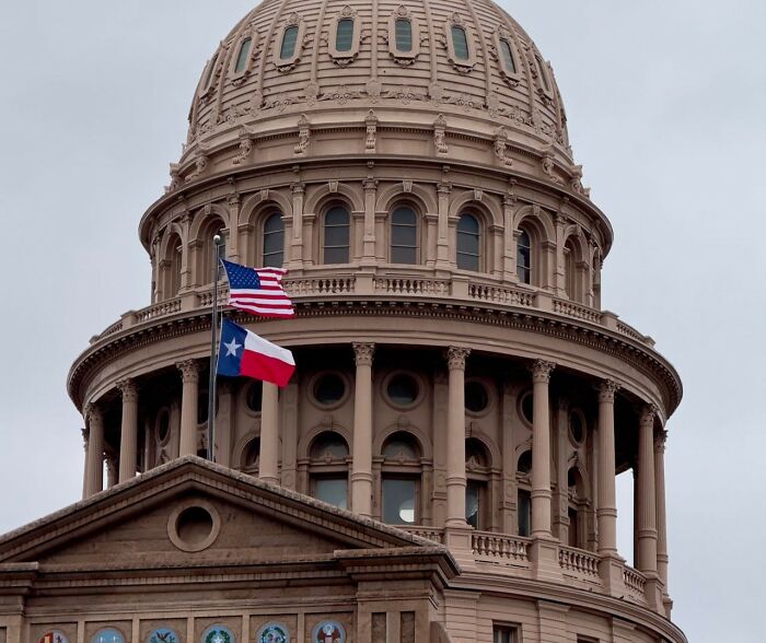 The dome of the Texas State Capitol, with American and Texas flags, symbolizing government and court case stories.