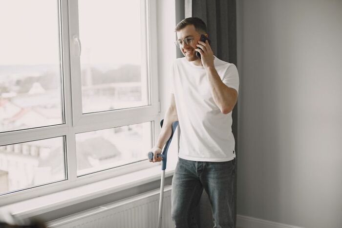 A man with crutches on a phone call, perhaps involved in one of the unbelievable court case stories.