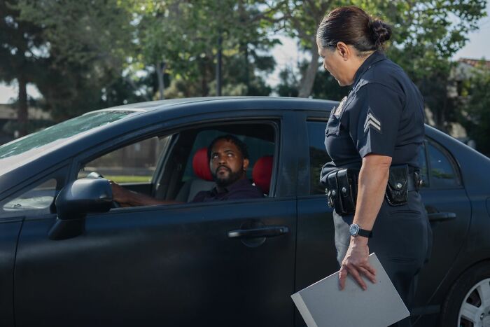A police officer talking to a driver in a car, illustrating a scene from potential court case stories.