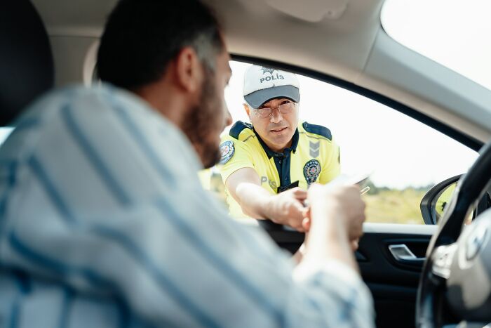 A police officer talking to a driver pulled over for a traffic stop, representing a court case story.