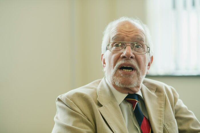 A senior man with a beard and glasses looking surprised, depicting a ridiculous court case story.