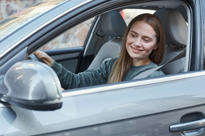 Smiling woman driving a car, a common scenario in many court case stories.