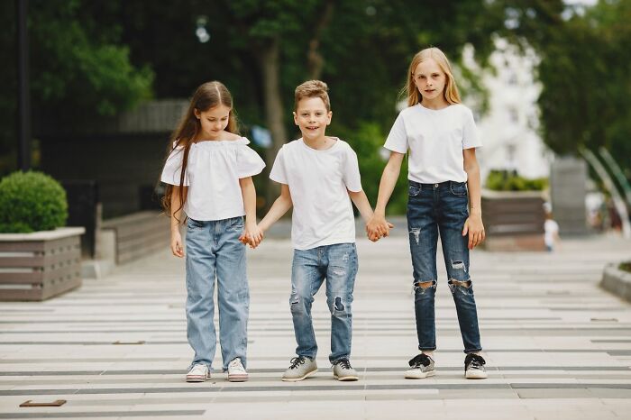 Three children holding hands and walking. This image might be part of a court case story involving family or custody.