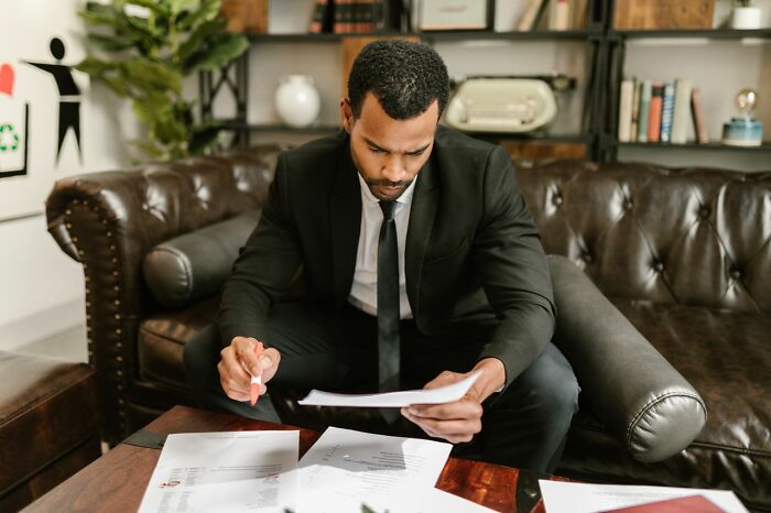 Man in a suit reviewing documents, representing legal work related to court case stories.