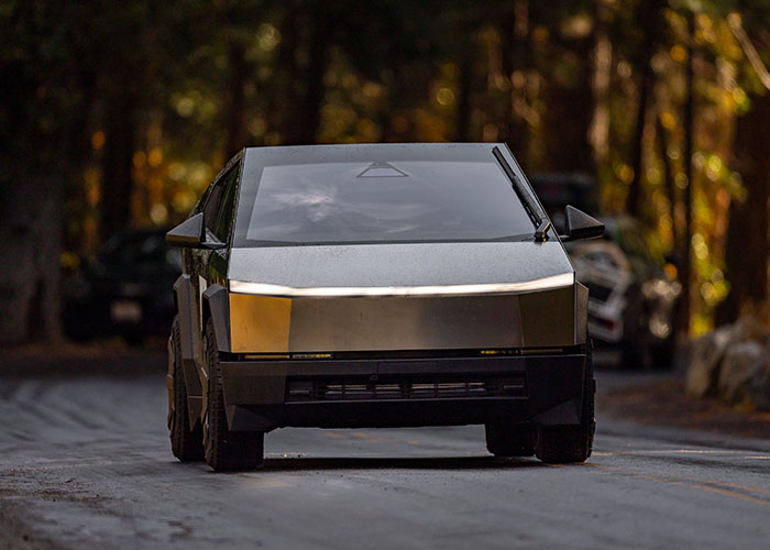 A futuristic black car on a road, representing a drastic change or purchase associated with a midlife crisis.