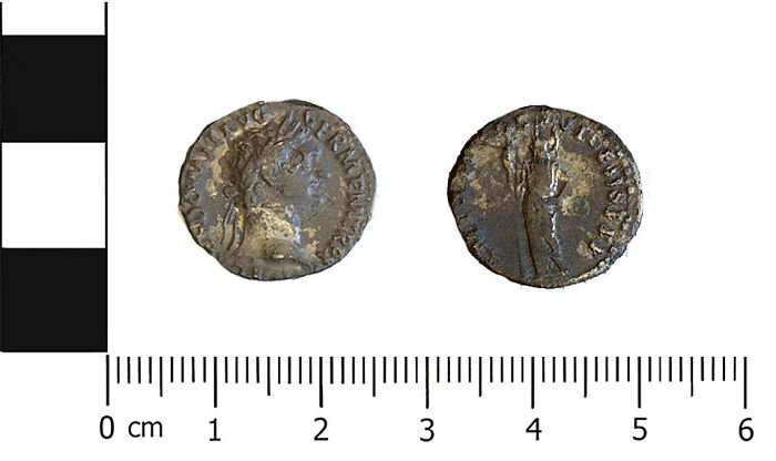 Close-up of two ancient Roman coins, historical artifacts that survived against the odds, showing intricate details on both sides.