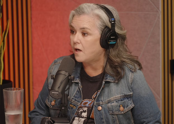 Rosie O'Donnell in a denim jacket with headphones and a microphone, discussing Trump rumors on Jimmy Kimmel.