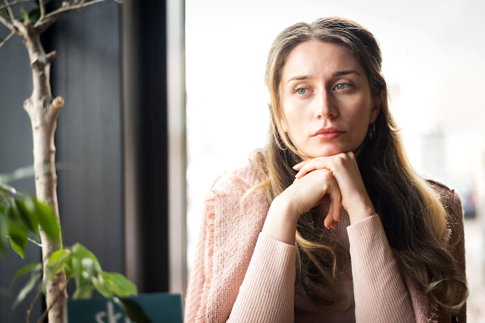 A woman with long hair and a thoughtful expression, highlighting how relationship red flags can impact mental health.
