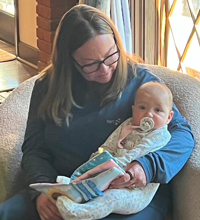 A woman holds a baby with a pacifier, illustrating the care needed to prevent leaving a baby in a hot car. A woman holds a baby with a pacifier, illustrating the care needed to prevent leaving a baby in a hot car.