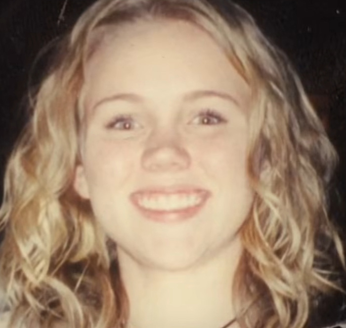 A young woman smiles brightly. She escaped a serial criminal and shares the warning sign she ignored.
