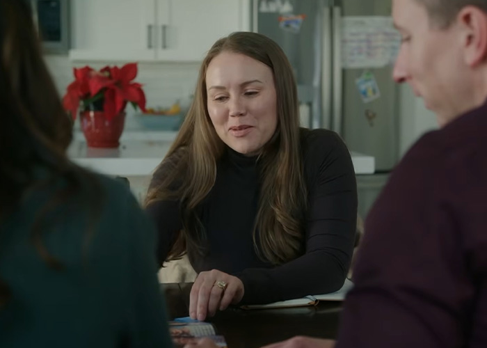 A woman who escaped a serial criminal smiles while talking to others, sharing her experience and warning signs.