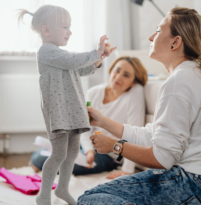A sister helps her sister have a baby, with a young child playing while another woman watches, keeping a secret. A sister helps her sister have a baby, with a young child playing while another woman watches, keeping a secret.