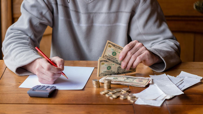 A guy handling money, possibly dealing with his girlfriend's request to split her son's sports fees. A guy handling money, possibly dealing with his girlfriend's request to split her son's sports fees.