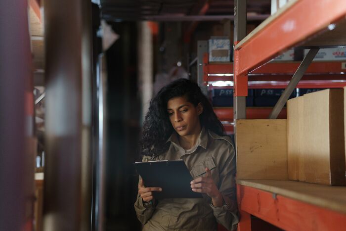 A woman doing inventory in a warehouse, representing the daily grind of workplace dramas.
