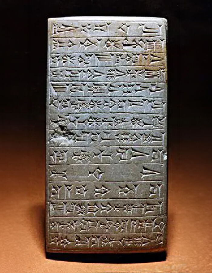 An ancient Mesopotamian cuneiform tablet, a historical artifact covered with intricate wedge-shaped inscriptions.