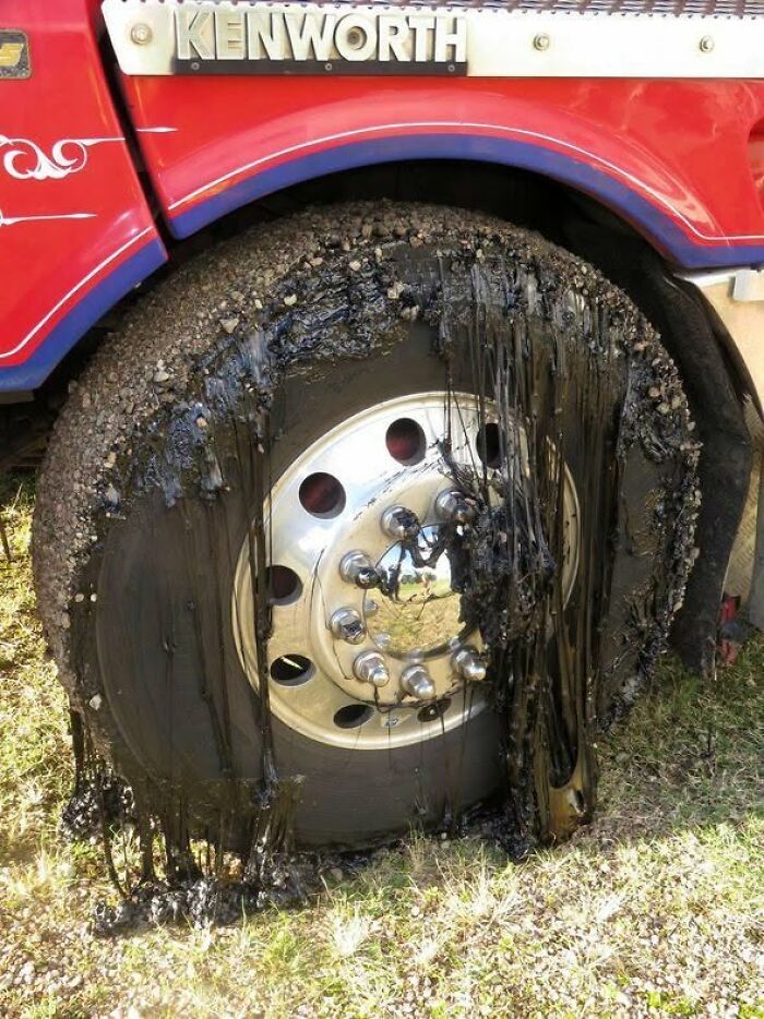 Truck tire covered in melted asphalt, showing the ruining effects of summer.