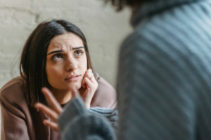 Woman expressing concern during a conversation, highlighting challenges in treating mental health disorders.