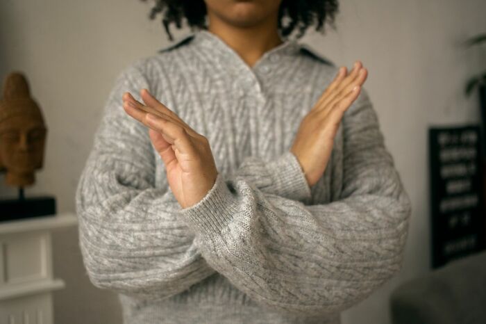 A person with crossed arms, demonstrating a boundary or refusal often related to mental health disorders.