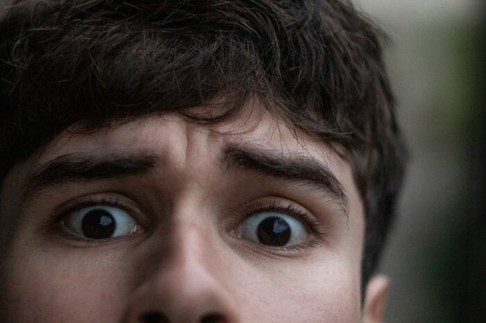 A man with wide, anxious eyes, representing the impact of mental health disorders that are difficult to treat.