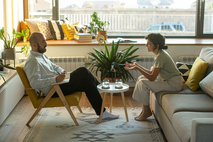 A man and a woman in a therapy session, discussing mental health disorders and their treatment difficulties.