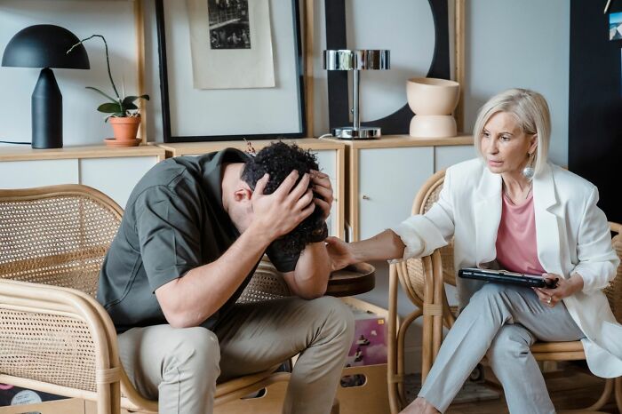 America does better with mental health support, as a therapist comforts a distressed man during a session.