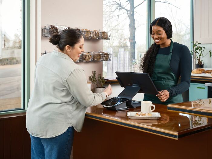 A customer making a purchase with a friendly cashier, illustrating the excellent customer service America does better.
