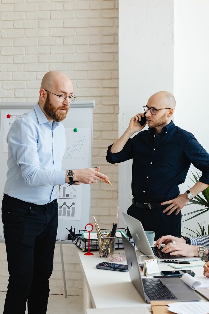 Two businessmen in a meeting discussing a whiteboard presentation, showcasing America's entrepreneurial spirit.