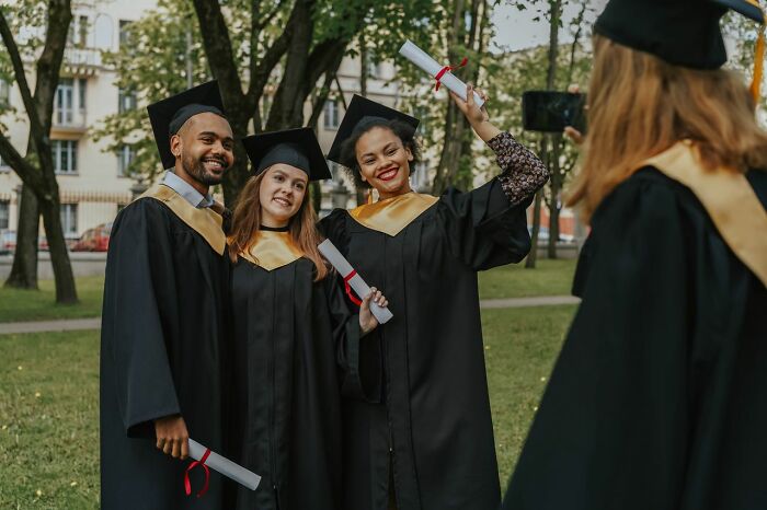 Diverse group of graduates posing for a picture, representing America's educational opportunities and diversity.
