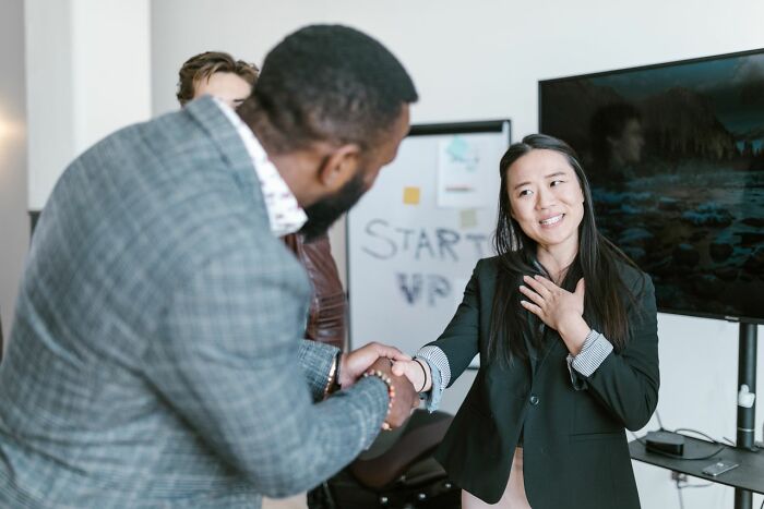 Two business professionals shaking hands, showcasing America's strong business acumen.