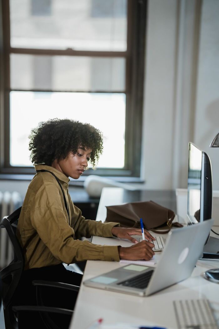 A woman working diligently at a desk, showcasing one of the things America does better, productivity.