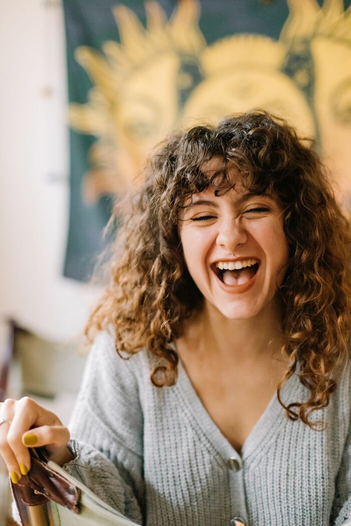 Woman laughing heartily, illustrating America's vibrant culture and emphasis on personal happiness and freedom.