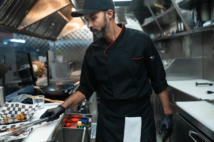 Chef in a food truck preparing a dish, highlighting America's culinary innovation and diverse food scene.