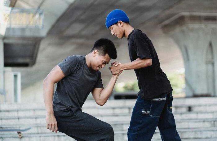 Two young men arm wrestling, showcasing competitive spirit and things America does better.