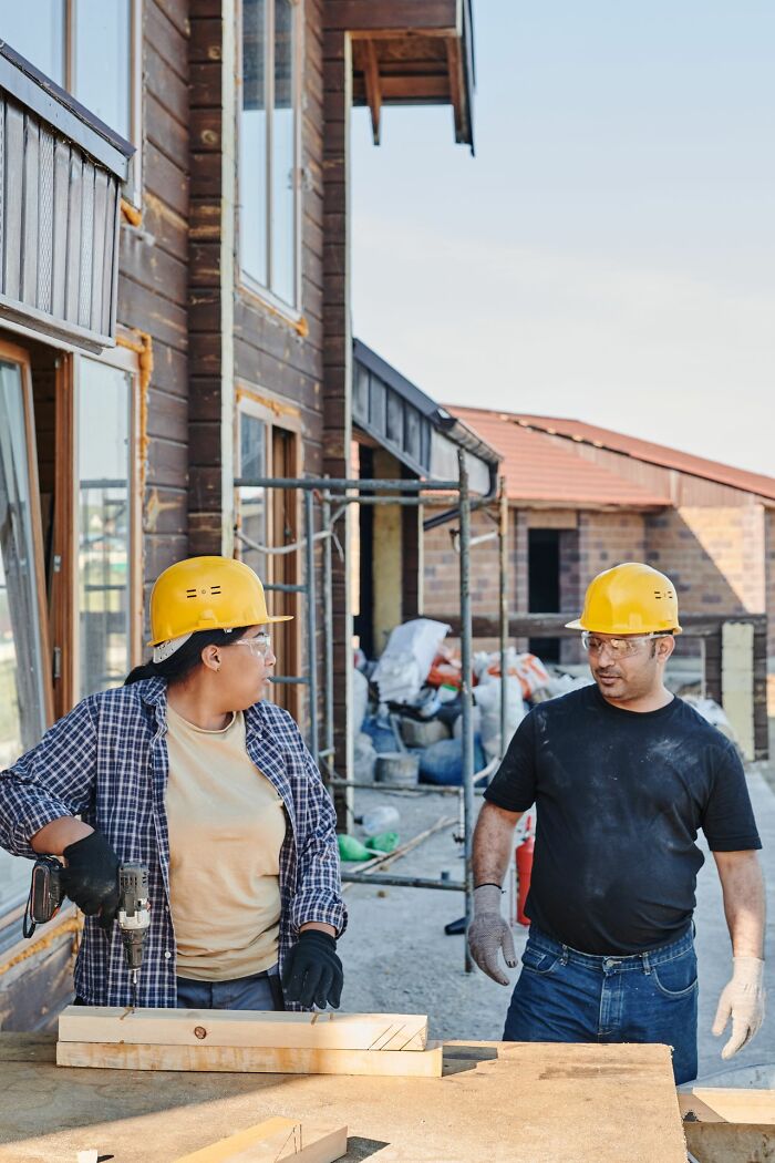 Construction workers in hard hats building, reflecting things America does better in industry.