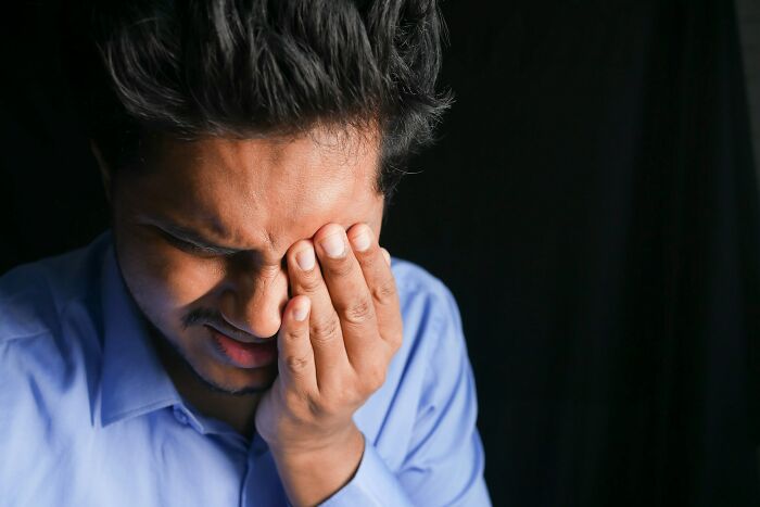 Man clutching his face in distress, symbolizing the profound emotions from stories of life and what comes after.