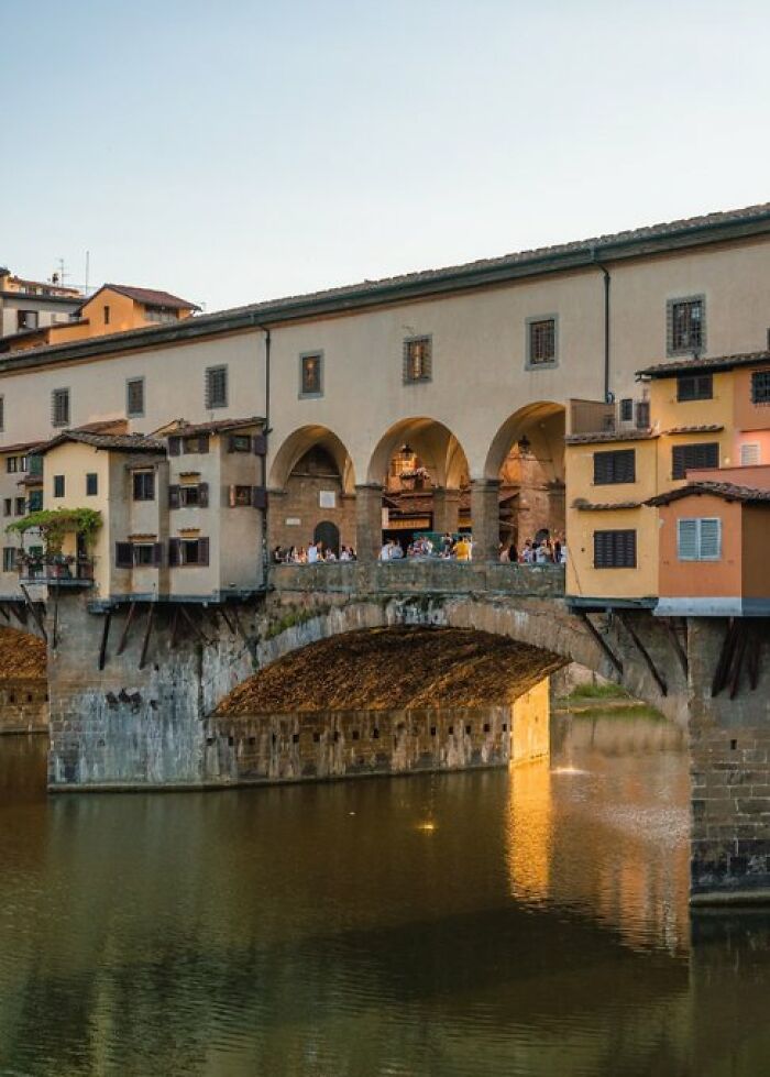 The iconic Ponte Vecchio bridge in Florence, Italy, with historical buildings built into its structure, displaying unique character.