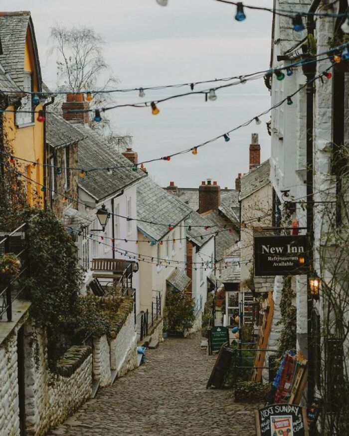 A charming cobblestone street adorned with colorful string lights and historical buildings, showcasing unique character.