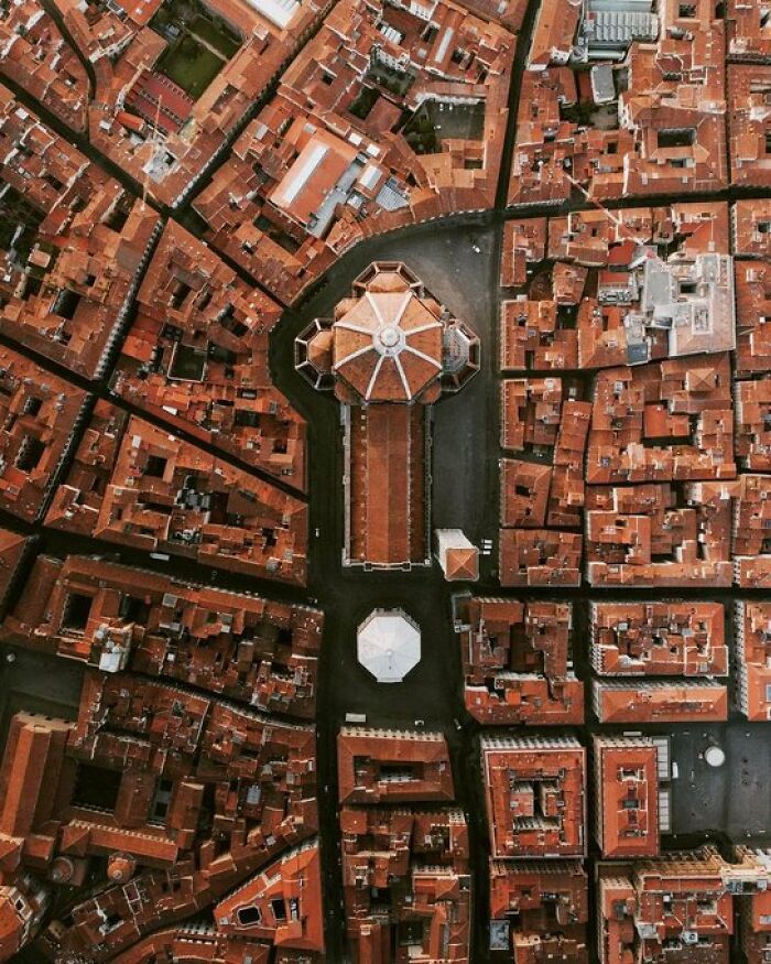 Overhead view of Florence, Italy, focusing on the cathedral amidst a dense urban fabric of buildings with character.