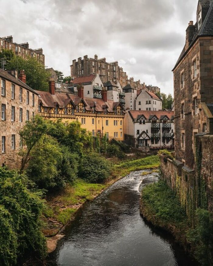 Historic buildings with character lining a winding river, showcasing unique architectural designs in a cityscape.